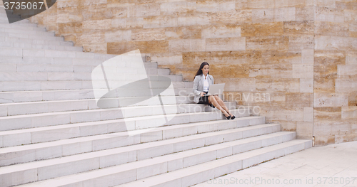 Image of Woman using laptop in the distance