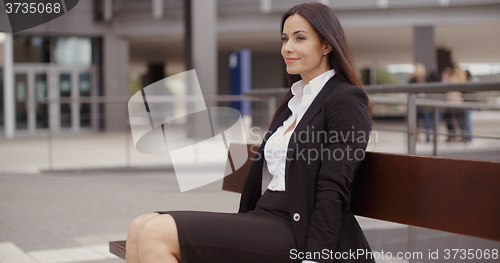 Image of Optimistic business woman sitting outdoors