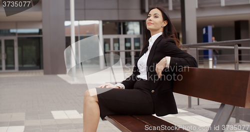 Image of Calm business woman sitting outdoors