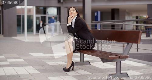 Image of Calm business woman sitting outdoors