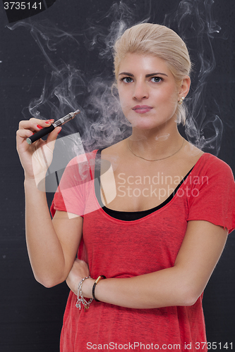 Image of Stylish blond woman smoking an e-cigarette