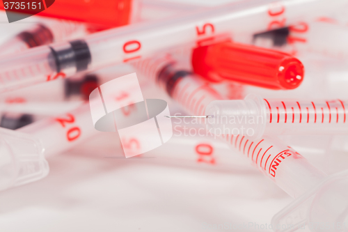 Image of Pile of Empty Syringes with Red Safety Caps