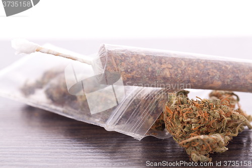 Image of Close up of dried marijuana leaves and joint