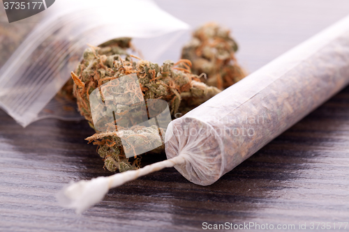 Image of Close up of dried marijuana leaves and joint