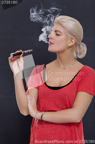 Image of Stylish blond woman smoking an e-cigarette