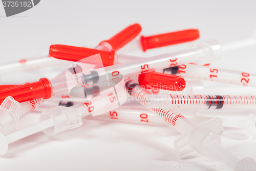 Image of Pile of Empty Syringes with Red Safety Caps