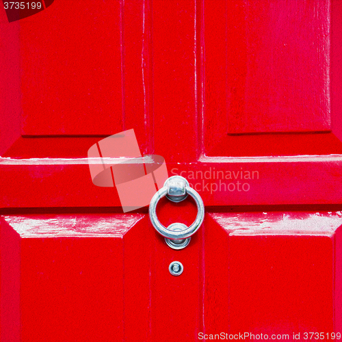 Image of red handle in london antique brown door  rusty  brass nail and l