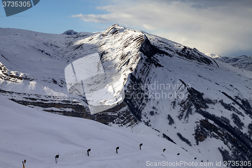 Image of Ski slope with snow cannon at evening