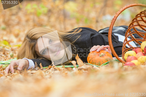 Image of Young beautiful girl lies on the on the foliage in the autumn forest