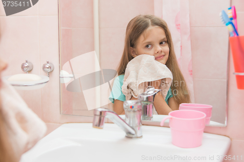 Image of The girl wiped a towel after washing in bathroom