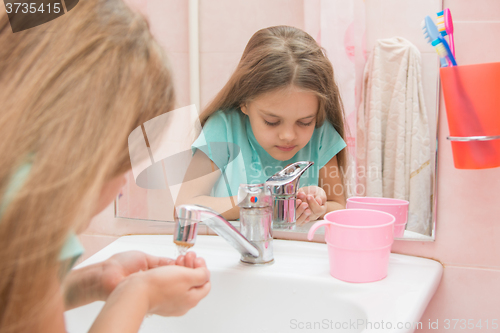 Image of Six year old girl washes in the bathroom