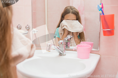 Image of Baby wipes face with a towel in the bathroom