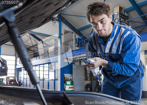 Image of Car mechanic under the hood