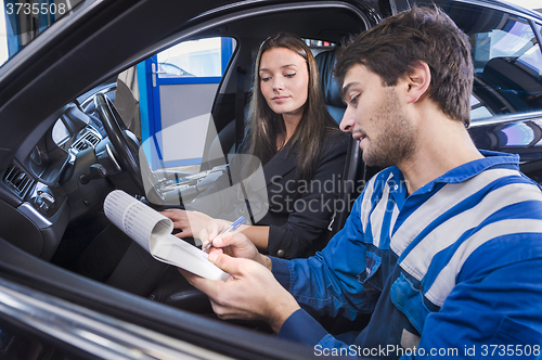 Image of Car expert shows reparations to customer