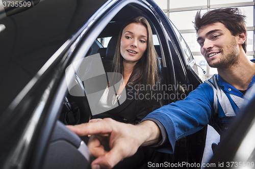 Image of Mechanic points out to customer what is fixed