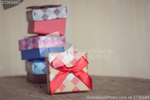 Image of Gift box with red bow on wood background