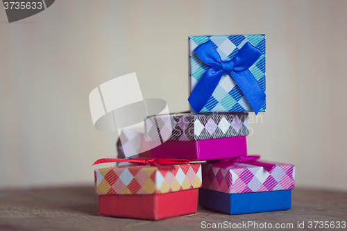 Image of Gift box with red bow on wood background