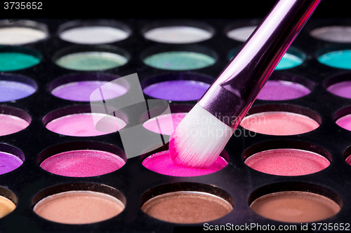 Image of Colorful eye shadows palette with makeup brush.