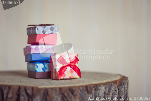 Image of Gift box with red bow on wood background