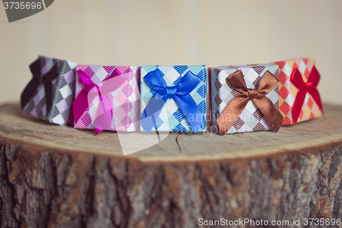 Image of Gift box with red bow on wood background