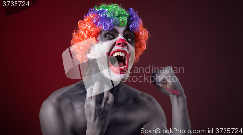 Image of crazy clown  with a knife