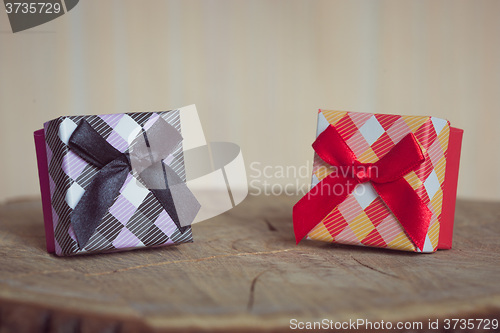 Image of Gift box with red bow on wood background