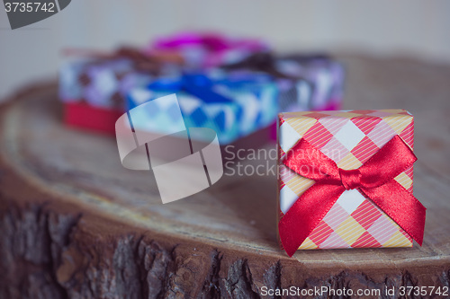 Image of Gift box with red bow on wood background