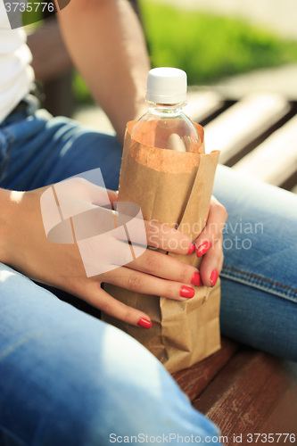 Image of girl holding a plastic bottle in a paper bag