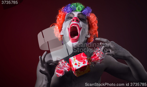 Image of scary clown with spooky makeup and more candy 