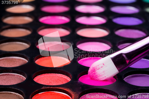 Image of Colorful eye shadows palette with makeup brush.