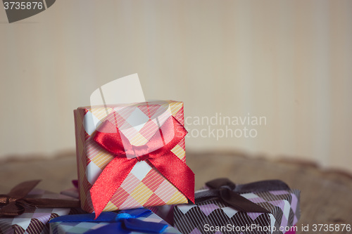 Image of Gift box with red bow on wood background