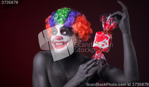 Image of scary clown with spooky makeup and more candy 