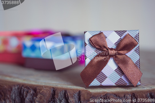 Image of Gift box with red bow on wood background