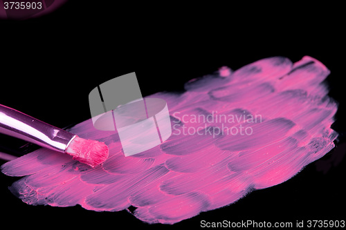 Image of lipstick with a brush make-up on black 