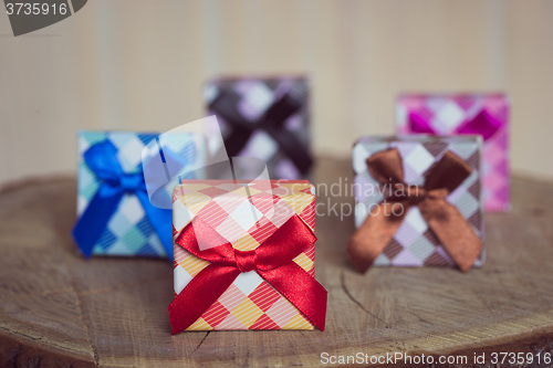 Image of Gift box with red bow on wood background