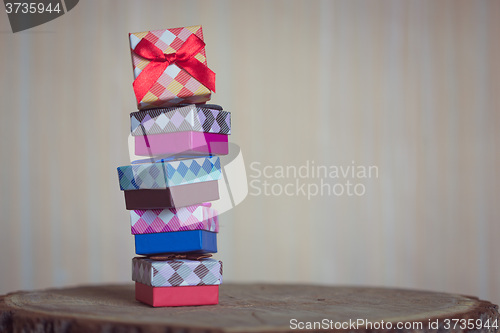 Image of Gift box with red bow on wood background