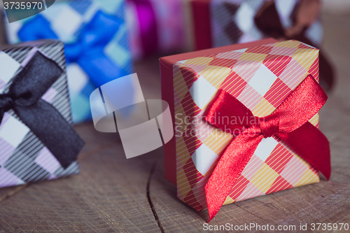 Image of Gift box with red bow on wood background