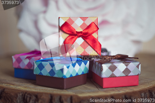 Image of Gift box with red bow on wood background