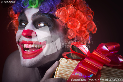 Image of scary clown makeup and with a terrible gift