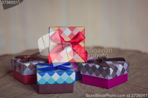 Image of Gift box with red bow on wood background
