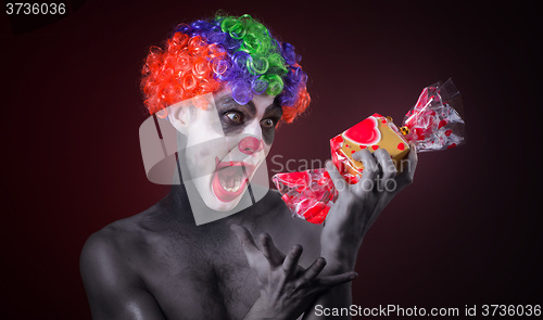 Image of scary clown with spooky makeup and more candy 