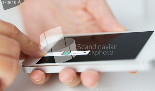 Image of close up of woman with smartphone doing blood test