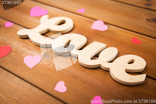 Image of close up of word love with red paper hearts