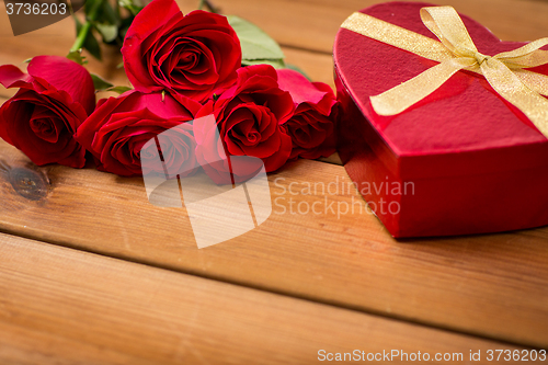 Image of close up of heart shaped gift box and red roses