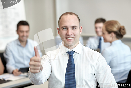 Image of group of smiling businesspeople meeting in office