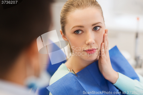 Image of male dentist with woman patient at clinic