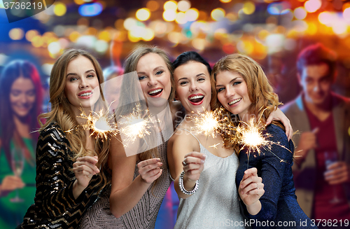 Image of happy young women with sparklers at night club