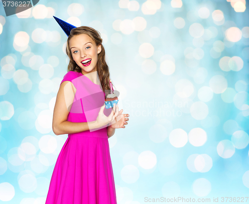 Image of happy woman or teen girl with birthday cupcake