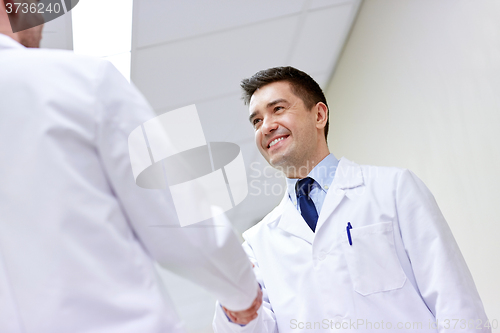 Image of smiling doctors at hospital doing handshake