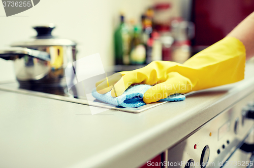 Image of close up of woman cleaning cooker at home kitchen